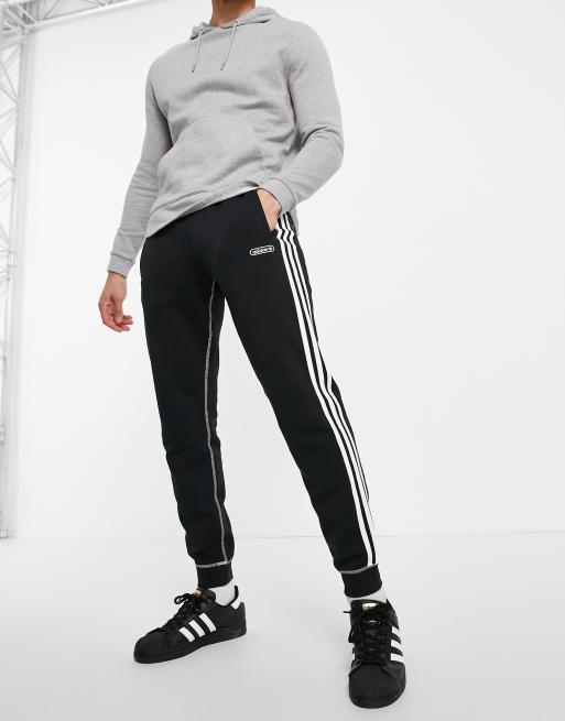 adidas Originals three stripe contrast stitch trackies in black | ASOS