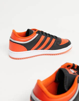 black adidas trainers with orange stripes