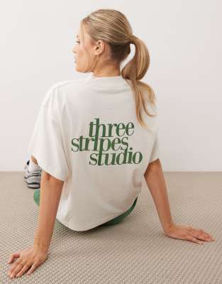 adidas Performance - Studios - T-Shirt in Weiß und Grün mit den drei Streifen
