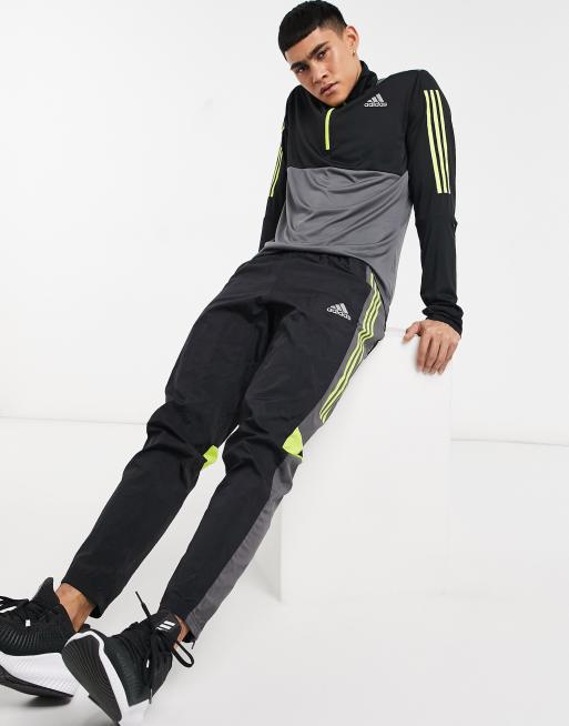 Black adidas pants store with yellow stripes