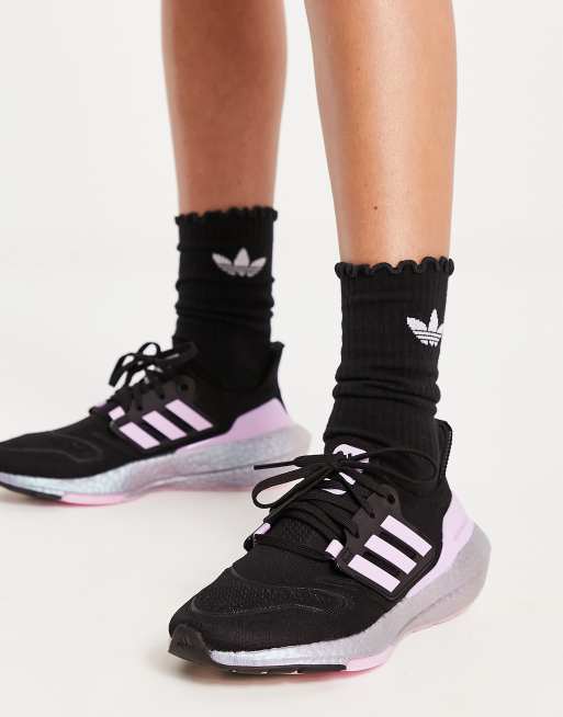 Black adidas store with pink soles