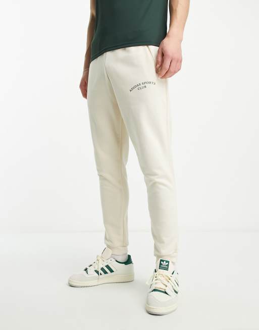 adidas Training Sports Club graphic trackies in white