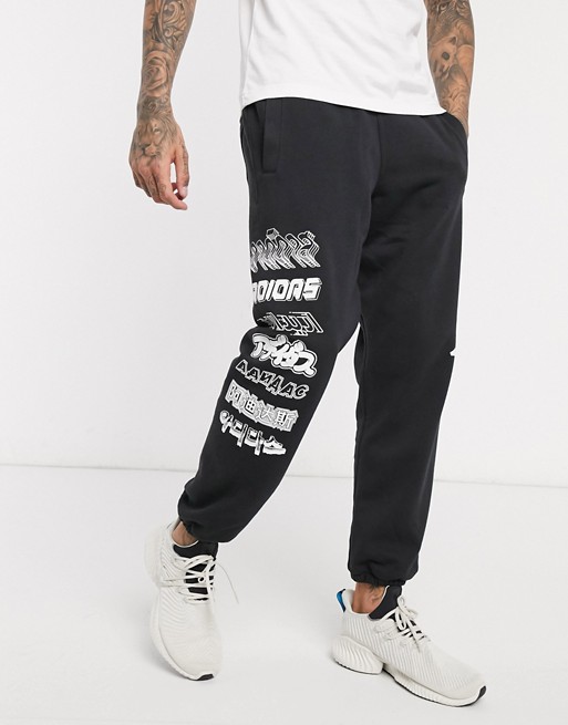 adidas woven joggers in black with side print