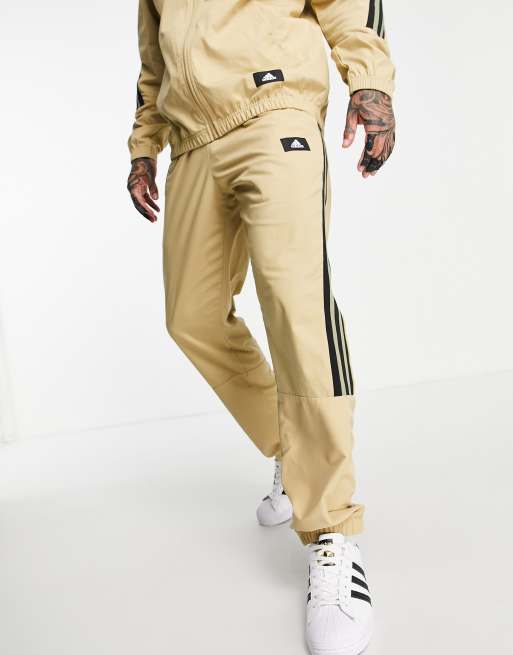 adidas woven sweatpants with three stripes in beige