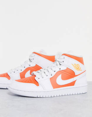 Jordan Air Jordan 1 Mid SE trainers in white and orange