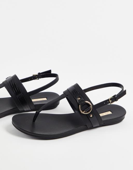 Aldo - Pandra - Flade sandaler i sort med T-stang og guldfarvede metaldetaljer 
