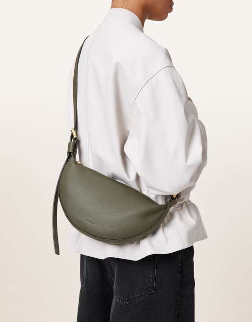 AllSaints – Ciemnozielona skórzana torebka crossbody w kształcie półksiężyca