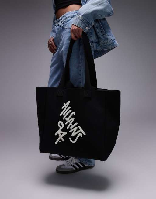 AllSaints - Izzy - Borsa shopping nera con scritta spray