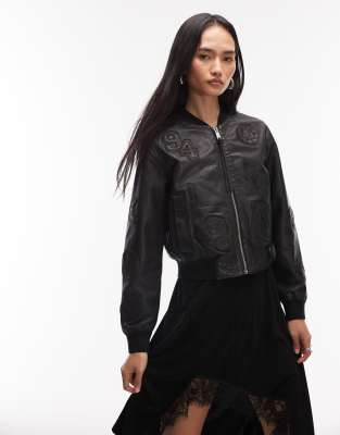 AllSaints - Orten - Cropped-Bomberjacke aus Leder in Schwarz mit 94-Patch