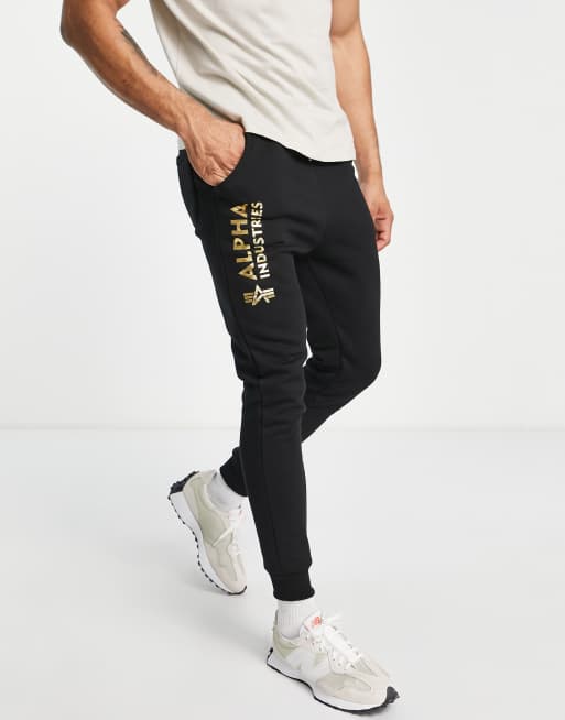 Alpha Industries - Joggers neri con fondo elasticizzato e logo laminato in coordinato