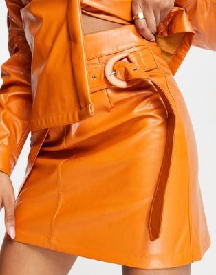 Amy Lynn PU mini skirt with slit detailing in tangerine