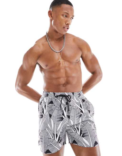 Another Influence swim shorts in black and cream leaf print