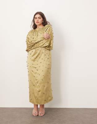 Макси-платье зеленого цвета с округлыми формами, украшенное шарикоподшипниками, сильными плечами и открытой спиной