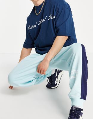 ASOS Actual coordinating oversized sweatpants with color block cut & sew detailing and logo print in blue