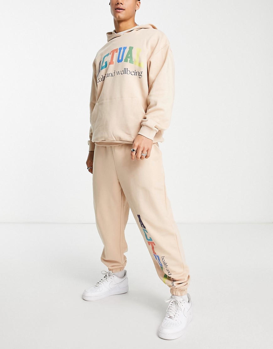 ASOS Actual relaxed sweatpants with multicolor logo print in beige - part of a set-Neutral