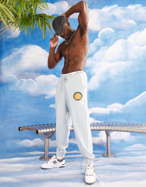ASOS Actual relaxed trackies with circle orange graphic print in blue (part of a set)