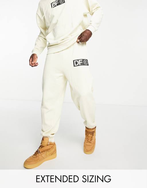 ASOS Dark Future relaxed trackies with front and back logo prints in ecru (part of a set)