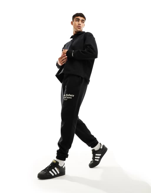 ASOS DARK FUTURE - Sorte og tapered joggingbukser med print