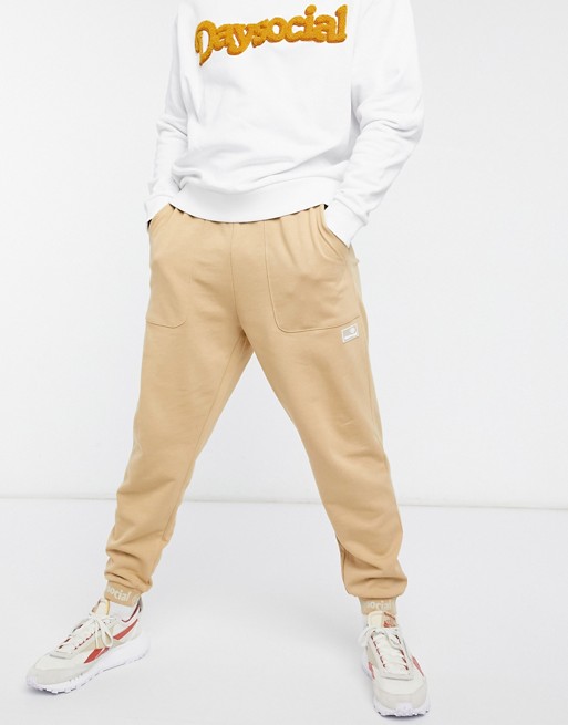 ASOS Daysocial oversized joggers with logo cuff detail in tan