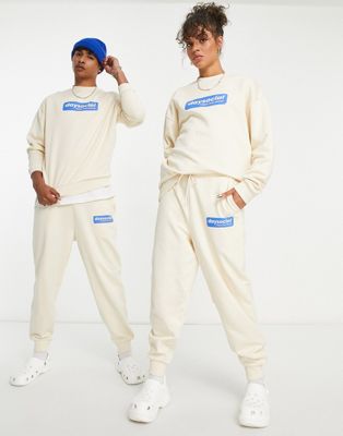 ASOS Daysocial unisex relaxed trackies with blue badge logo print in ecru (part of a set) - ASOS Price Checker