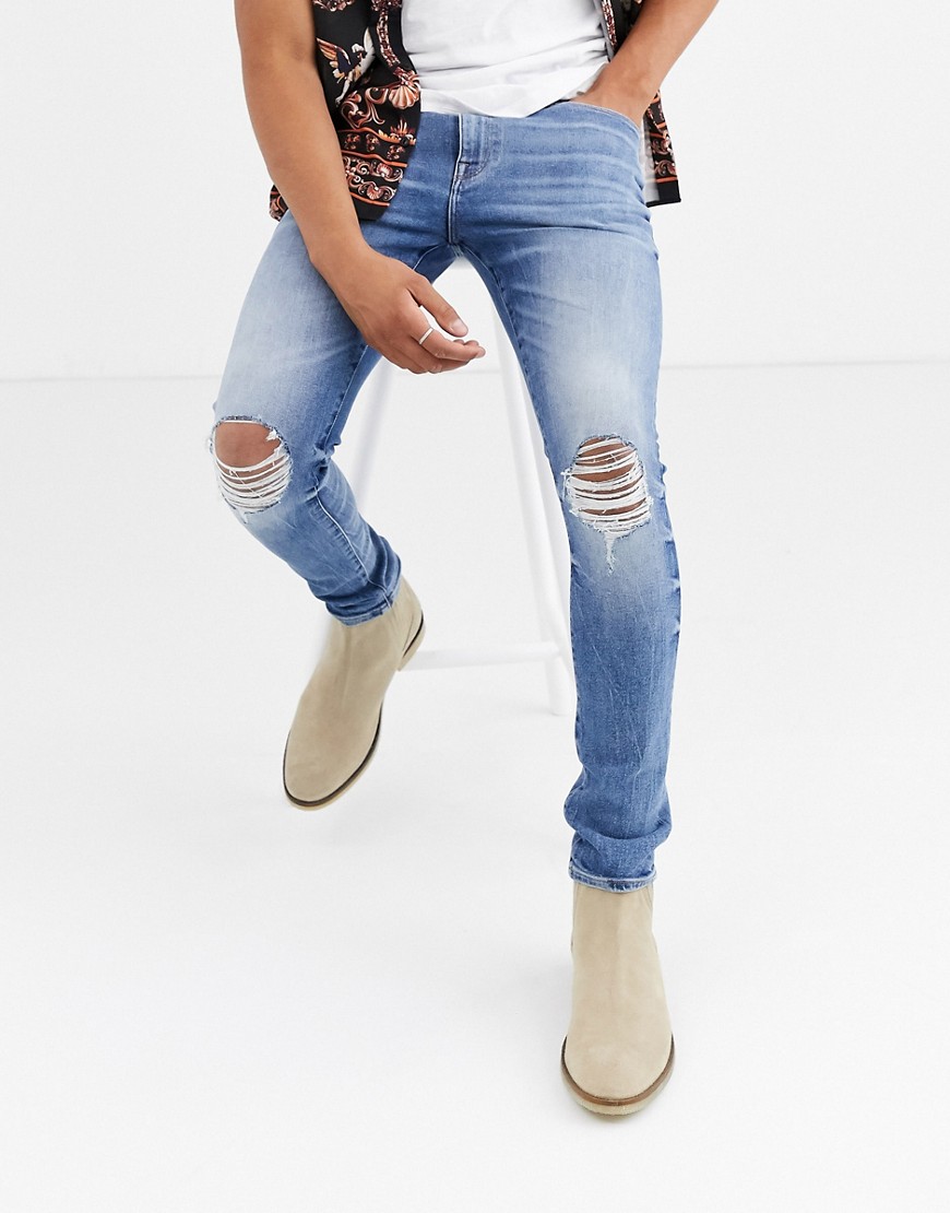 ASOS DESIGN 12.5oz 'Cigarette' skinny jeans in mid wash blue with busted knees