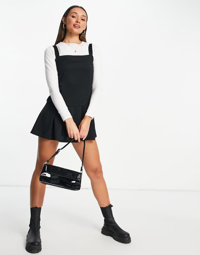 ASOS DESIGN 2-in-1 pleated black pinny dress with white long sleeve top