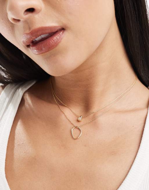 ASOS DESIGN – 2er-Pack goldfarbene Halsketten mit Ringanhänger in geschmolzener Optik und künstlichem Halbedelstein