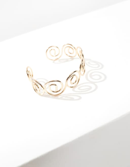 ASOS DESIGN arm cuff with swirl design in gold tone