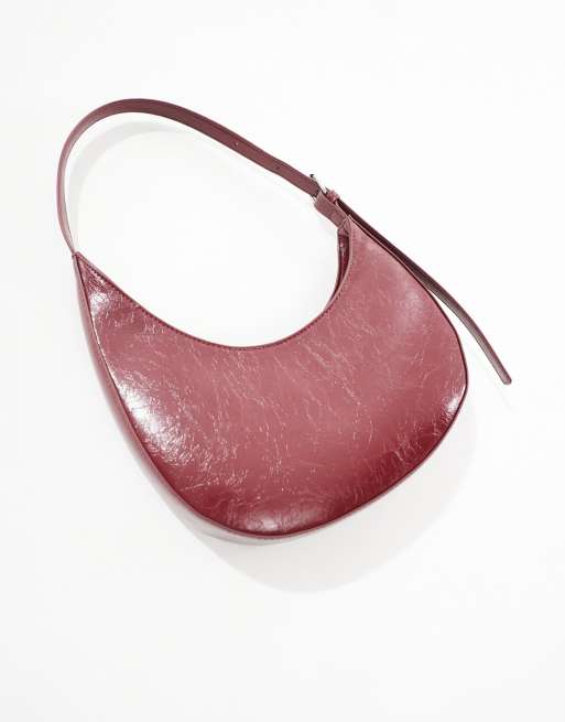 ASOS DESIGN asymmetric scoop shoulder bag with buckle detail in burgundy