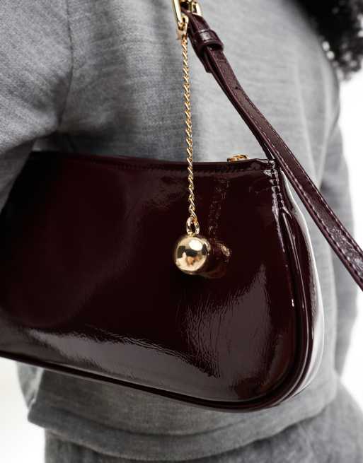 ASOS DESIGN asymmetric shoulder bag with buckle and removable ball charm in burgundy, 4 of 4