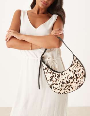 ASOS DESIGN - Asymmetrisch-halbmondförmige Schultertasche aus Ponyhaar mit Schnallendetail und Kuhfleckenmuster-Bunt