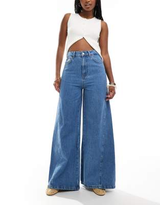 ASOS DESIGN - Ausgestellte Jeans in mittelblauer Waschung mit Godet-Einsätzen