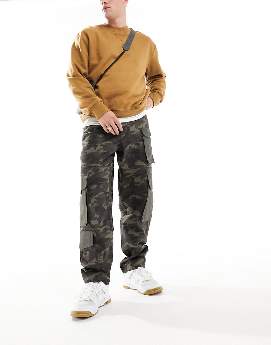 ASOS DESIGN baggy cargo trouser in all over camo print with contrast pockets and panelled detail-Gre