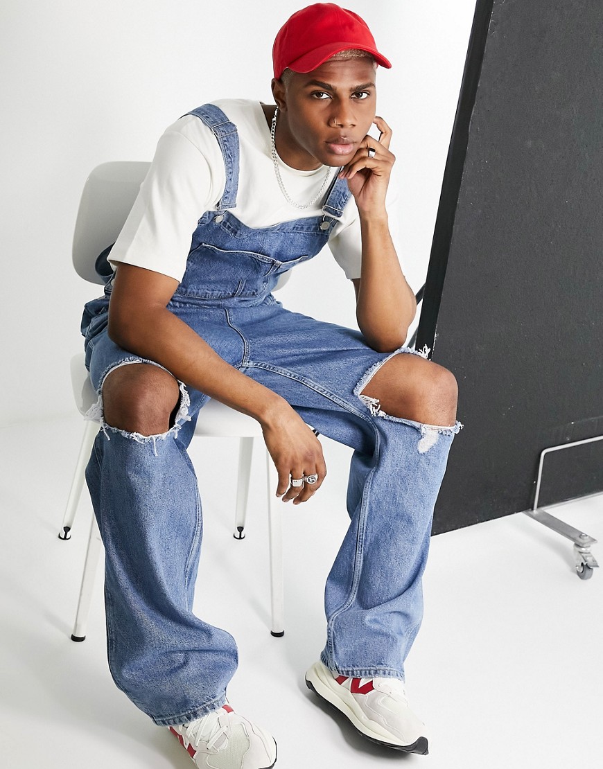 ASOS DESIGN baggy denim overalls in mid wash with knee rips-Blues