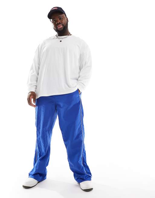 ASOS DESIGN baggy nylon track pants in blue with white piping