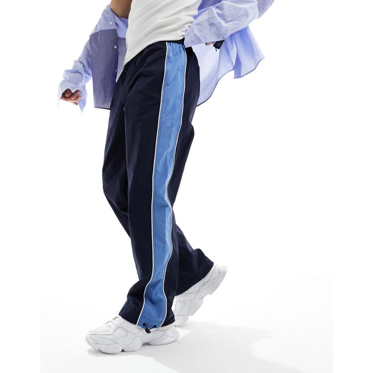ASOS DESIGN baggy nylon track pants in navy with blue side stripe