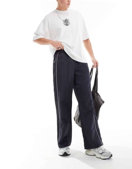 ASOS DESIGN baggy nylon track pants in navy with white piping