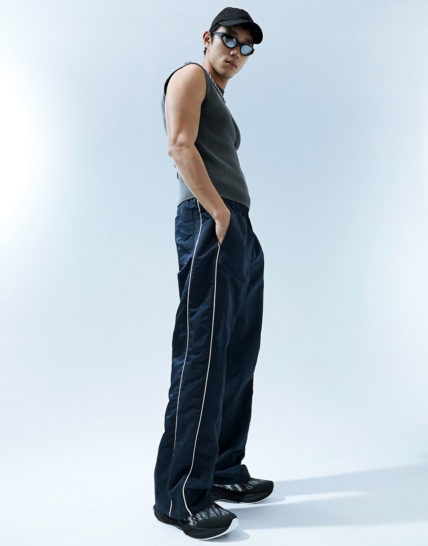 ASOS DESIGN baggy nylon track pants in navy with white piping