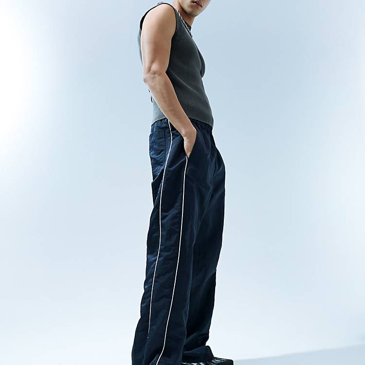 ASOS DESIGN baggy nylon track pants in navy with white piping