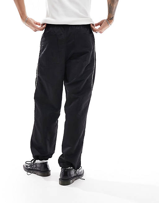 ASOS DESIGN baggy nylon track pants with contrast piping in black