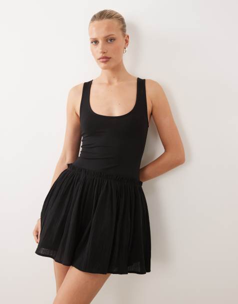 ASOS DESIGN – Baumwoll-Minikleid in Schwarz mit tief angesetzter Taille und Rockteil mit Knitterstruktur - view 1