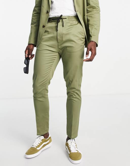 ASOS DESIGN – Bawełniane zwężane spodnie garniturowe w kolorze khaki z troczkami w pasie i wywijanymi mankietami