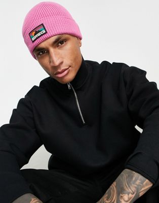 ASOS DESIGN fisherman ribbed beanie with rubber logo in pink - ASOS Price Checker