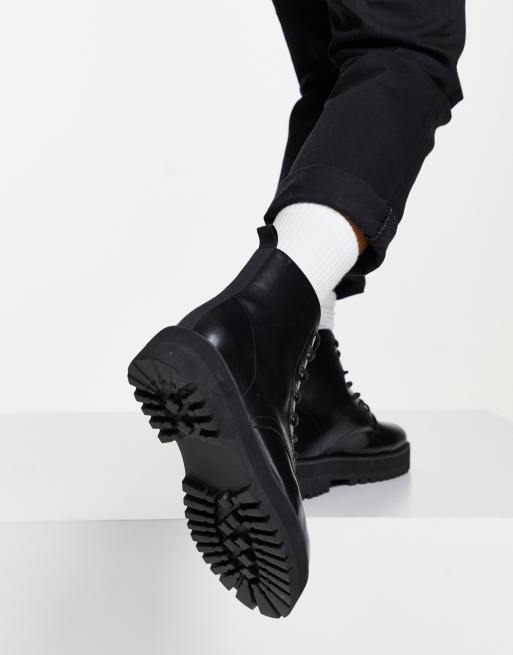 Bottes De Cuir Noir Avec De Grosses Semelles, Porté Par Une Femme Avec Des  Chaussettes Arraché Stripey Banque D'Images et Photos Libres De Droits.  Image 921743