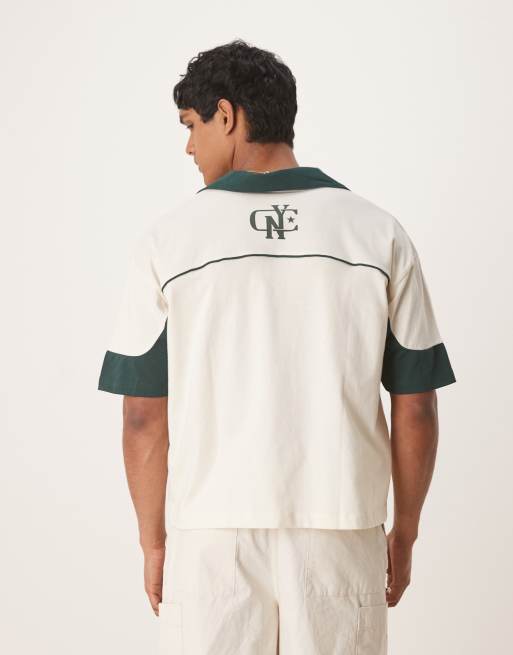 ASOS DESIGN boxy oversized polo shirt with cut and sew paneling and city graphics in cream