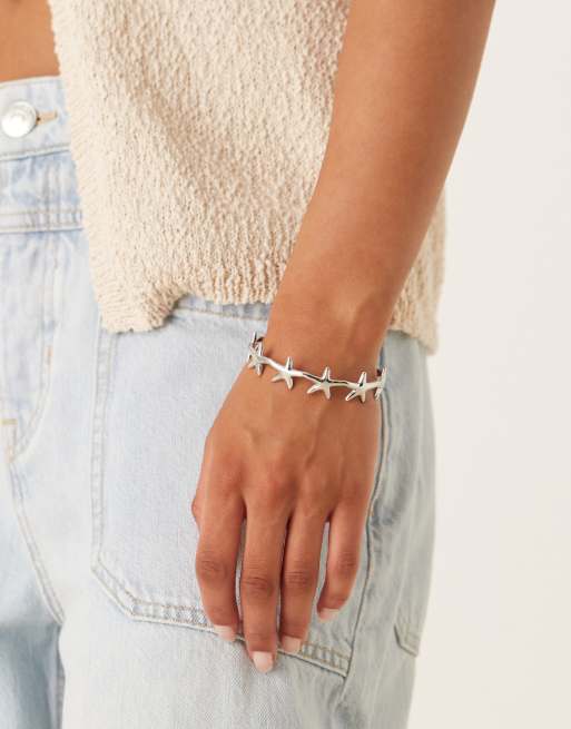 ASOS DESIGN - Bracciale rigido in acciaio inossidabile resistente all'acqua argentato con dettagli a forma di stelle marine piccole