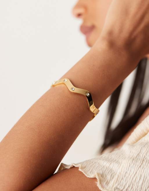 ASOS DESIGN - Bracciale rigido tonalità oro in acciaio inossidabile resistente all'acqua con decorazioni