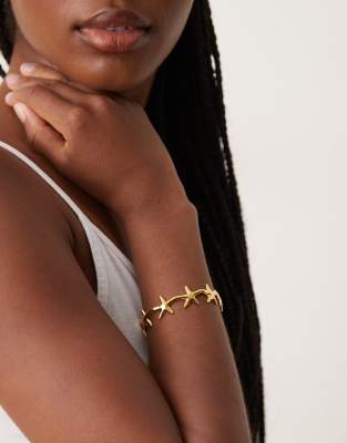 ASOS DESIGN - Bracelet jonc en acier inoxydable étanche avec petite étoile de mer - Doré