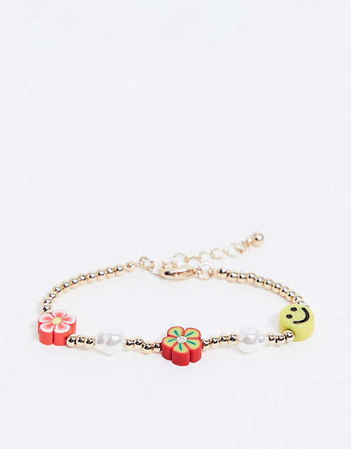 ASOS DESIGN bracelet with flower and happy face beads in gold tone