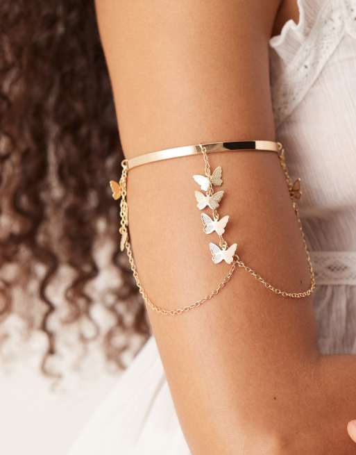 ASOS DESIGN – Bransoletka mankiet w odcieniu złota z łańcuszkami z motylkami